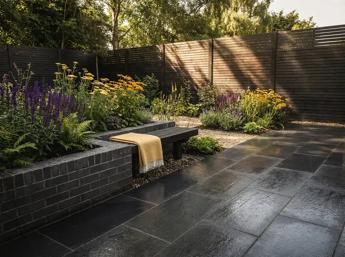 Contemporary outdoor patio with black slate tiles and garden border.
